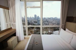 a bedroom with a large window with a city view at Menteng Park Exclusive Emerald in Jakarta
