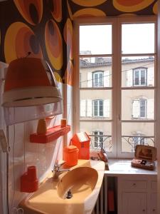 a bathroom with a sink and two windows at Vintage ,le paradis des enfants wifi draps parking free in Thiers