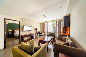 a living room with two couches and a table at Swiss-Belhotel Rainforest in Kuta