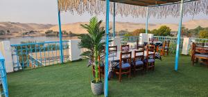 Basmatic Nubian Guest House في أسوان: مطعم على طاولة وكراسي على شرفة