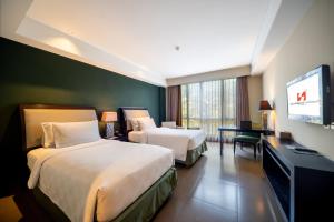 Postel nebo postele na pokoji v ubytování Swiss-Belhotel Rainforest