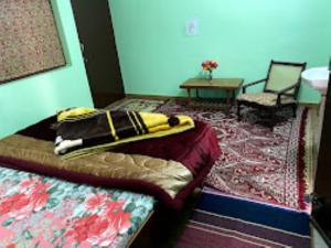 Schlafzimmer mit einem Bett, einem Tisch und einem Teppich in der Unterkunft YATRA HOMESTAY Joshimath in Jyotirmath