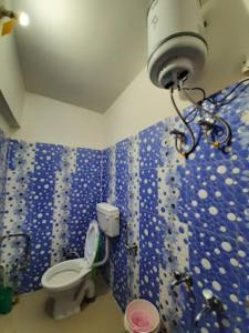 a bathroom with a toilet and a blue wall at YATRA HOMESTAY Joshimath in Joshīmath