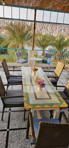 Basmatic Nubian Guest House في أسوان: طاولة وكراسي على فناء به نخيل
