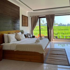 a bedroom with a bed with a view of a field at Kubu Bali Baik Villa & Resort - CHSE Certified in Ubud