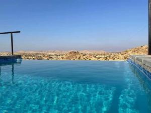 una gran piscina de agua azul en el desierto en Stofpad Lodge and Camping, 