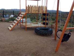 einen Spielplatz mit einem Reifen und einer Schaukel in der Unterkunft Stofpad Lodge and Camping 