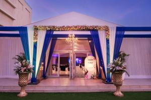 un chapiteau avec des rideaux et des fleurs bleus et une porte dans l'établissement Ginger Greater Noida Pari Chowk, à Greater Noida