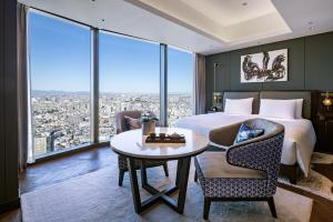 東京にあるBELLUSTAR TOKYO, A Pan Pacific Hotel のベッド、テーブル、椅子が備わるホテルルームです。