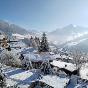 ein schneebedecktes Dorf mit Bergen im Hintergrund in der Unterkunft Alpbachblick in Alpbach