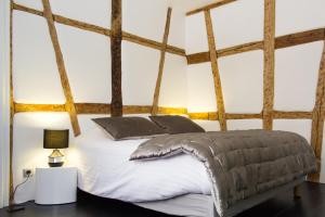 a bed in a room with wooden beams at MY SWEET HOMES - Appartements avec SPA in Colmar