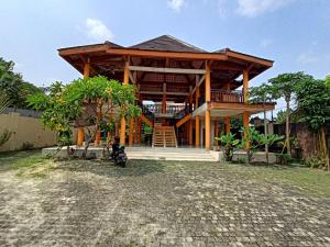 a wooden house with a motorcycle parked in front of it at Kost Salsabila Cisauk in Kedemangan-wetan