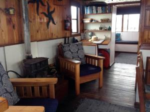 a living room with a stove and a chair and a table at Knysna Houseboat Myrtle in Knysna