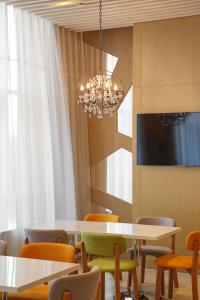 a dining room with tables and chairs and a chandelier at Holiday Inn Express Jinan High-Tech Zone, an IHG Hotel in Jinan