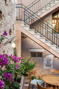 a patio with flowers and a table and stairs at Hotel Off in Chania