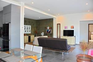ein Wohnzimmer mit einem Tisch und einem TV in der Unterkunft 2 Bedroom Villa with Pool & Close to Setangi Beach in Mangsit