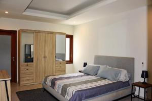 Schlafzimmer mit einem Bett und einem Holzschrank in der Unterkunft 2 Bedroom Villa with Pool & Close to Setangi Beach in Mangsit