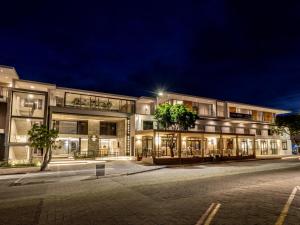 a large building at night with a street at Plett Quarter Apartments in Plettenberg Bay