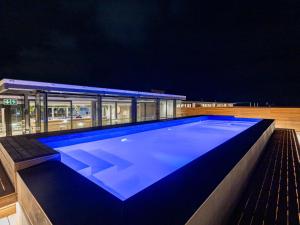 una piscina por la noche con un edificio en Plett Quarter Apartments, en Plettenberg Bay