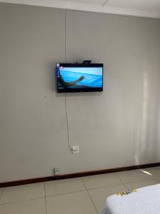 a flat screen tv on a white wall in a room at M D J Hayfields Guest House in Pietermaritzburg