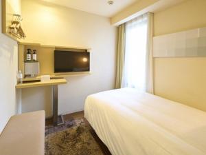 a hotel room with a bed and a tv at Hotel Resol Ikebukuro in Tokyo