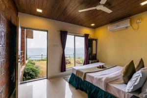 ein Schlafzimmer mit einem Bett und einem großen Fenster in der Unterkunft Lifeline Villas - Miracle Villa 5bhk Valley View in Mahabaleshwar