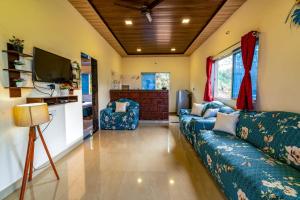 ein Wohnzimmer mit einem Sofa und einem TV in der Unterkunft Lifeline Villas - Miracle Villa 5bhk Valley View in Mahabaleshwar