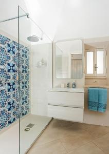 a bathroom with a sink and a glass shower at Caprita Guest House in Anacapri