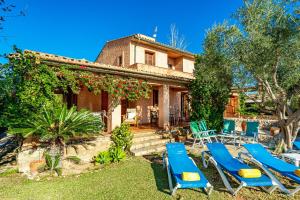 a house with blue lounge chairs and a yard at Can Xisco Pollensa in Port de Pollensa