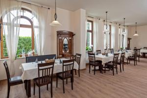 a restaurant with white tables and chairs and windows at Hotel Reichskrone in Heidenau