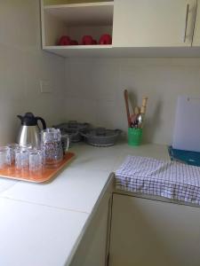eine Küchentheke mit einem Wasserkocher und Geschirr in der Unterkunft THE ROYAL STAYS in Galu