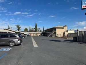 a parking lot with cars parked in front of a building at El Cajon Inn & Suites in El Cajon