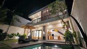 a villa with a swimming pool and a house at Villa Niu Center Canggu - FattyLion in Canggu