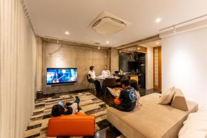a group of children sitting in a living room watching tv at Tre Casa Hotel Kamakuraみんなとの一体感で特別な想い出を鎌倉駅徒歩三分ママが安心できる宿で最大五名小町通り目の前 in Kamakura