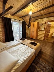 a large bed in a room with a large window at Oberig Apartmens in Vorokhta