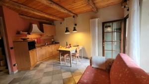 a kitchen with a couch and a table in a room at Baita 3 lovely & central Sauze in Sauze dʼOulx