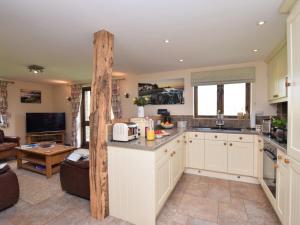 a kitchen with white cabinets and a living room at 2 Bed in Widemouth Bay WOOWW in Poundstock