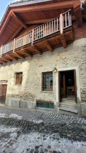 a building with a balcony on top of it at Baita 3 lovely & central Sauze in Sauze dʼOulx