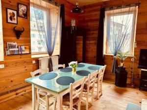 comedor con mesa azul y sillas en Appart. spacieux et lumineux 4 pers. en Morez