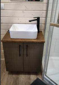 ein weißes Waschbecken auf einer Holztheke im Bad in der Unterkunft Tiny House Waldschmied 2 