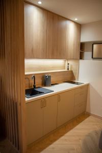 a kitchen with wooden cabinets and a sink at Barbara 76 in Ustroń +11 photos