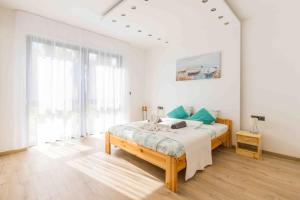 1 dormitorio blanco con 1 cama grande con almohadas azules en Tóparti Villa, Jakuzzi,Luxus élmény a Szigetközben, en Győrzámoly