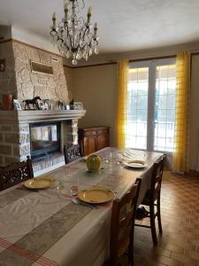 a dining room with a table and a fireplace at La maison du bonheur in Beaumes-de-Venise