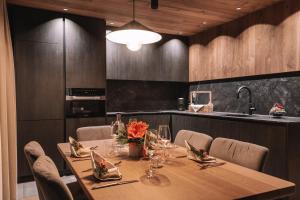 a dining room with a table with chairs and a kitchen at Residence Chalet L'Salvan in Selva di Val Gardena