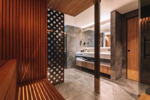 a bathroom with a bench and a sink at Residence Chalet L'Salvan in Selva di Val Gardena