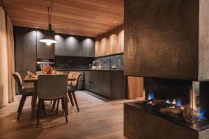 a kitchen and dining room with a fireplace at Residence Chalet L'Salvan in Selva di Val Gardena