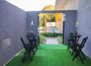 a patio with two tables and chairs on a green floor at Hotel Paddock in São Paulo