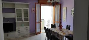 una sala da pranzo con pareti viola e tavolo con sedie di APPARTAMENTI RIMINI NEL CUORE a Rimini