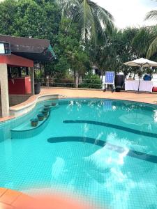 uma grande piscina com água azul em Renovated 2 Bedroom Seavilla for 6pax em Pantai Cenang