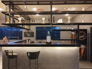 um bar com duas cadeiras e uma garrafa de vinho em Hotel Paddock em São Paulo